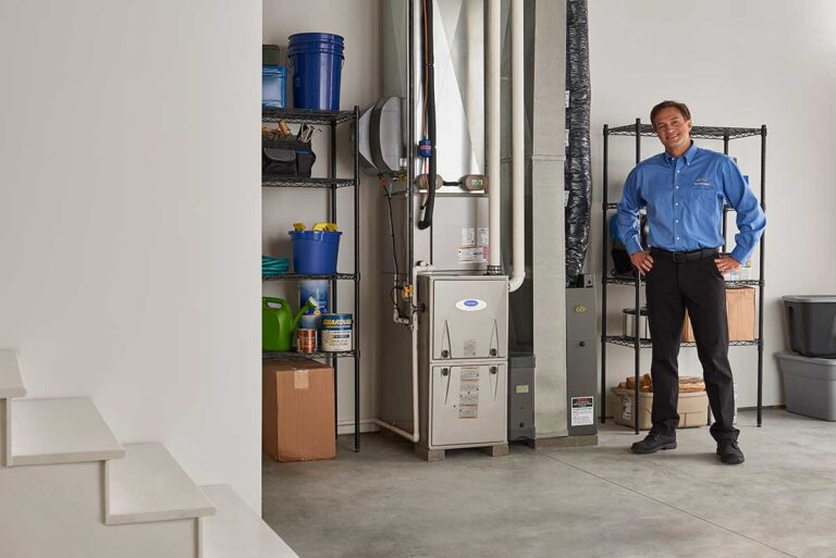 worker standing next to a carrier furnace