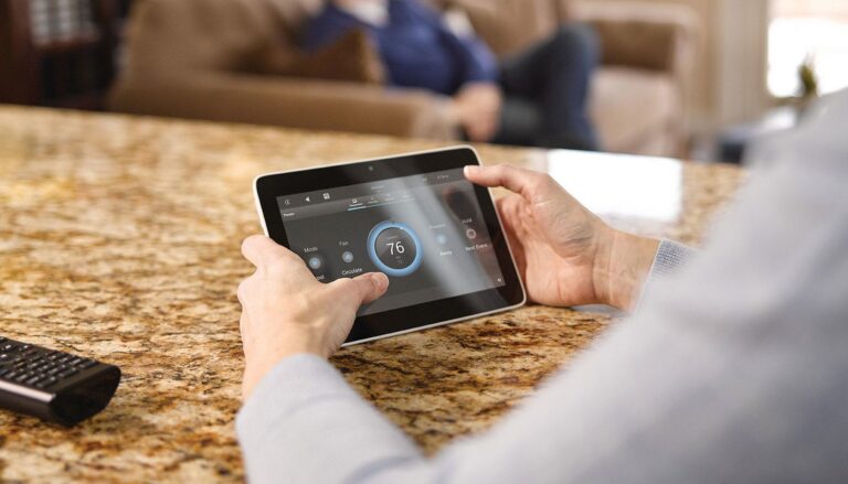 person holding a tablet adjusting their wifi thermostat